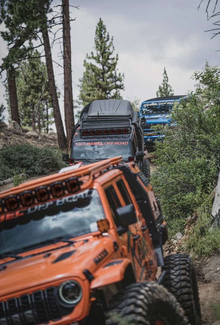 Off road vehicles drive through a rocky terrain
